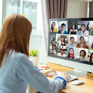 A red-headed woman video chats with her remote team